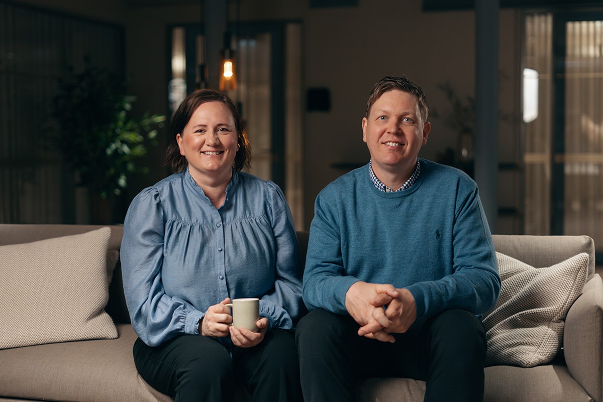 Eiendomsmegler og bankrådgiver som sitter sammen i en sofa. Foto.