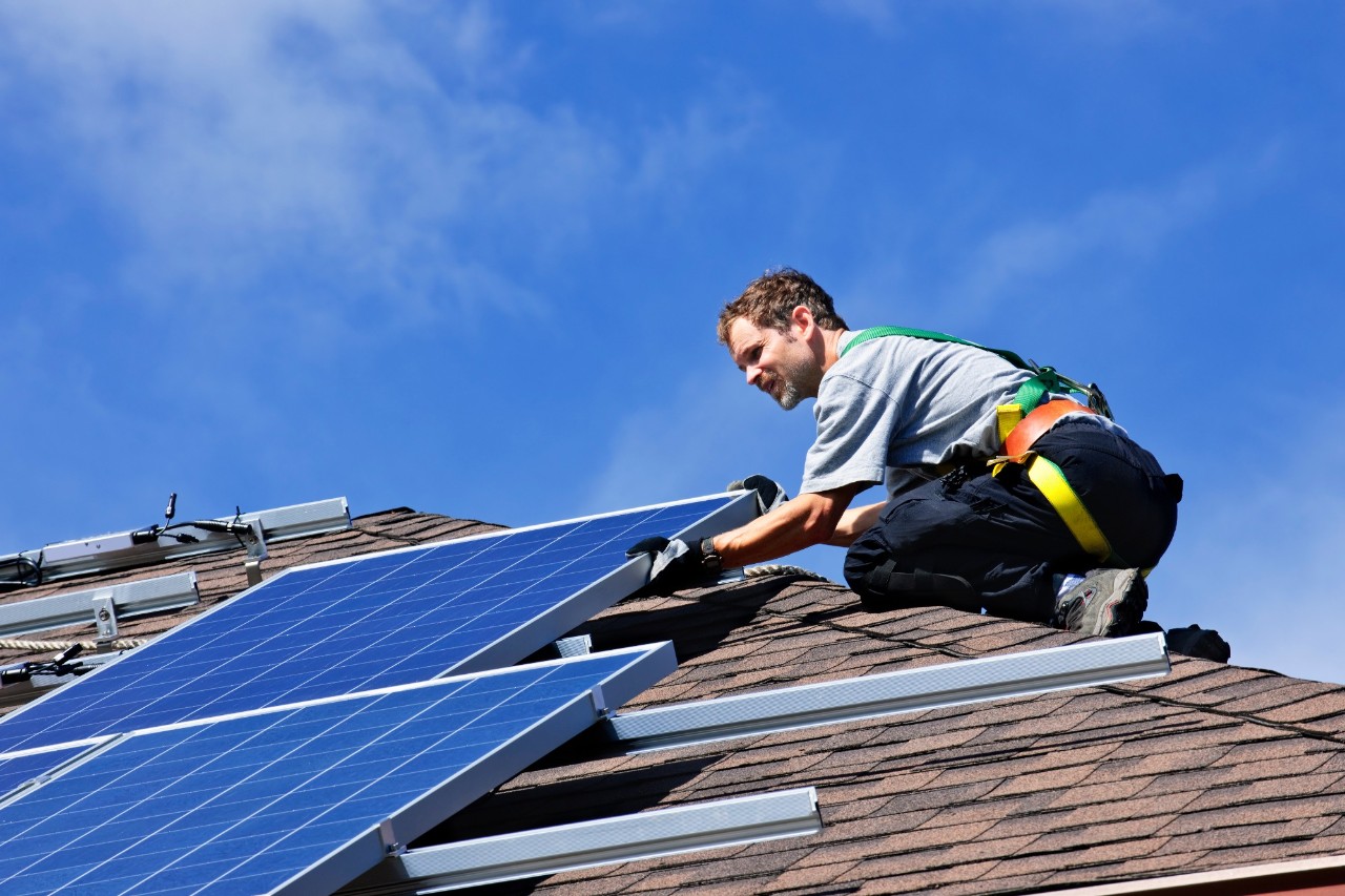elektriker installerer solcellepanel på tak
